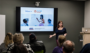 woman presenting to a room of people